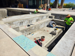 A crew of handymen working on pool construction and tiling for Premier Paradise, Inc. in Gilbert, AZ.