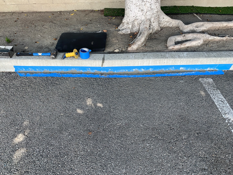 Tools and blue tape used for curb repair by Hollywood Handyman in Glendale, CA.
