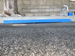 Curb sealing work in progress with blue tape by Hollywood Handyman in Glendale, CA.