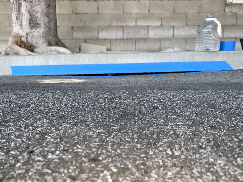 Curb sealing work in progress with blue tape by Hollywood Handyman in Glendale, CA.