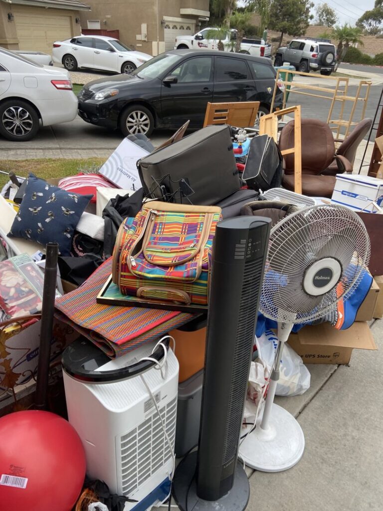 A large pile of assorted household junk and debris placed curbside for removal by Gabriel's Hauling & Junk Removal Services in San Diego, CA.
