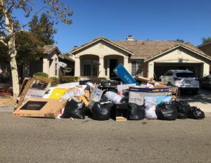 A large pile of household junk, including a TV and boxes, placed curbside for removal by Sac Junk in Rancho Cordova, CA