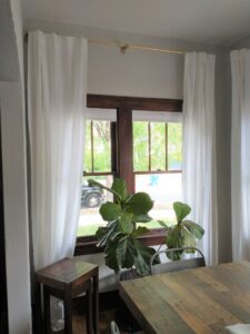 White curtains hung on a newly installed curtain rod above a window by Boise Handyman & Remodel in Boise, ID.