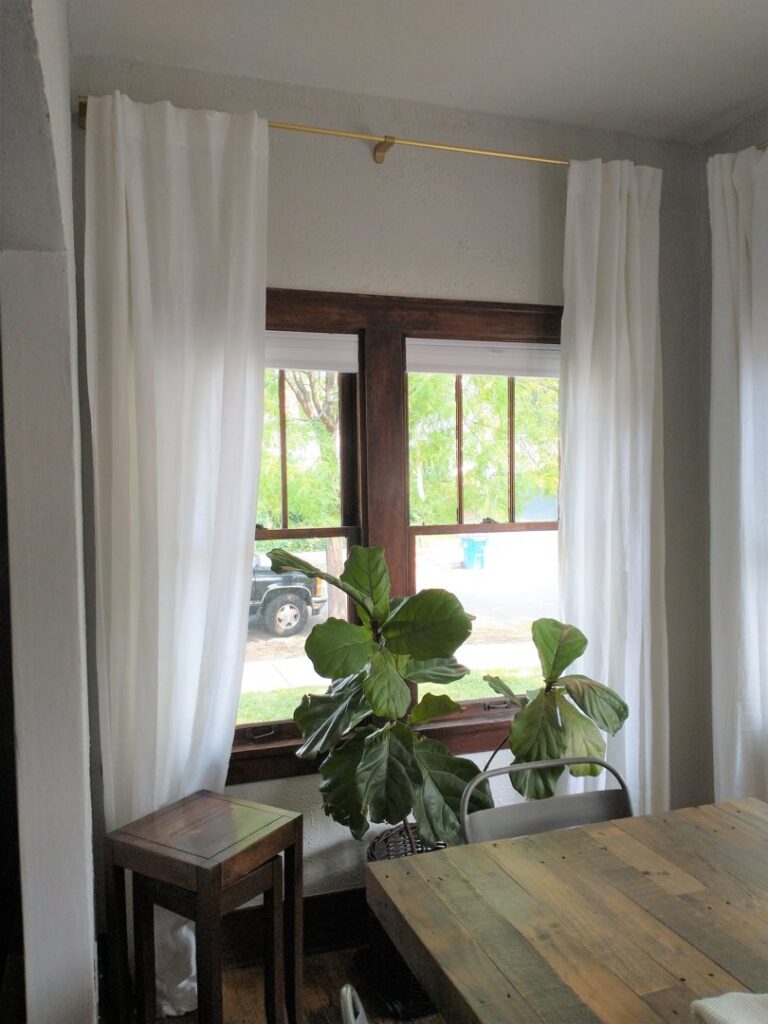 White curtains hung on a newly installed curtain rod above a window by Boise Handyman & Remodel in Boise, ID.