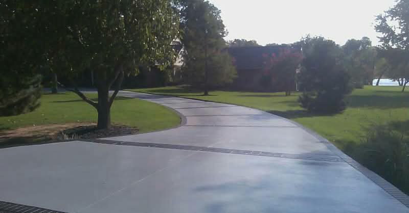 A long, curved concrete driveway with decorative borders, installed by All American Concrete in Crescent, OK.