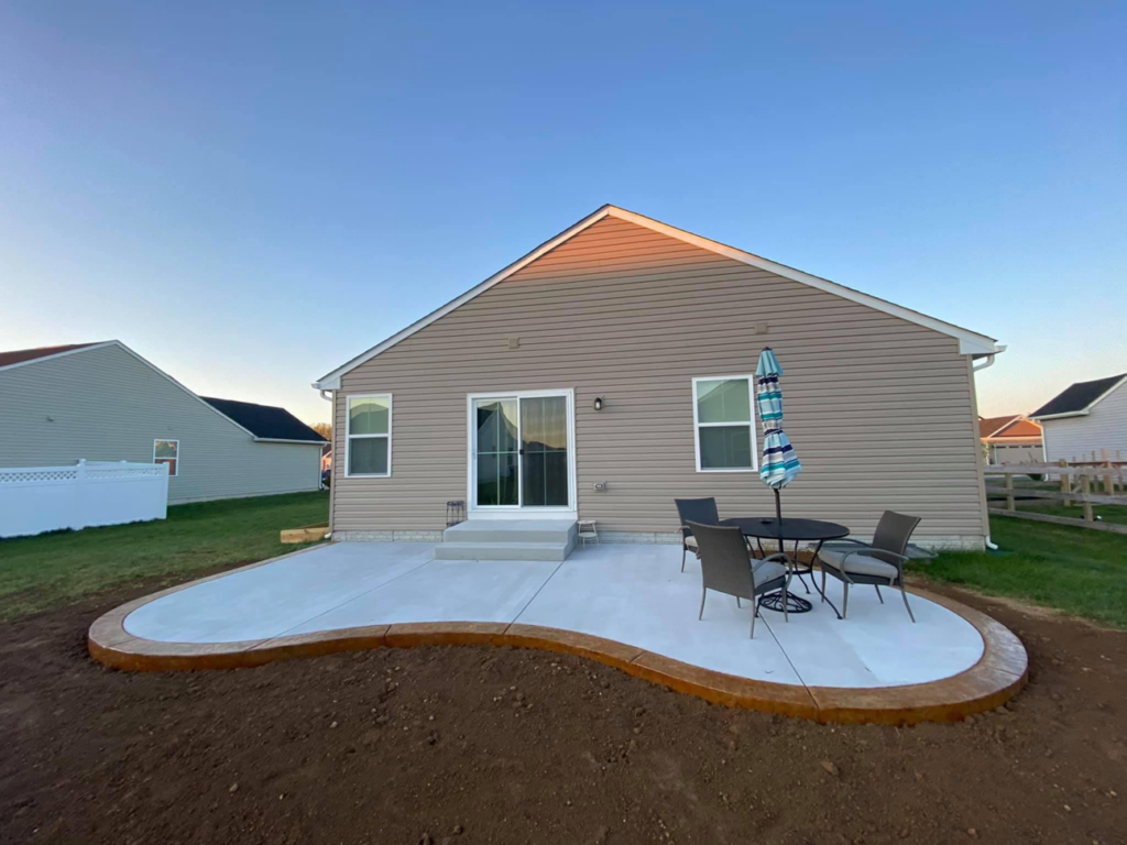 A newly installed curved concrete patio with outdoor furniture by Lafayette Concrete & Remodel, LLC in Lafayette, IN
