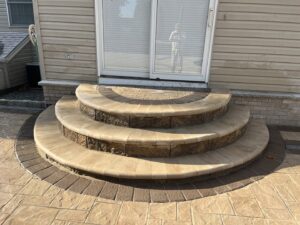 Newly installed curved paver steps and patio leading to a sliding glass door by Mincho Contractor LLC in Jersey City, NJ