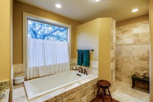 A custom home bathroom featuring a large soaking tub and a separate tiled shower by Aubrey Homes in Austin, TX