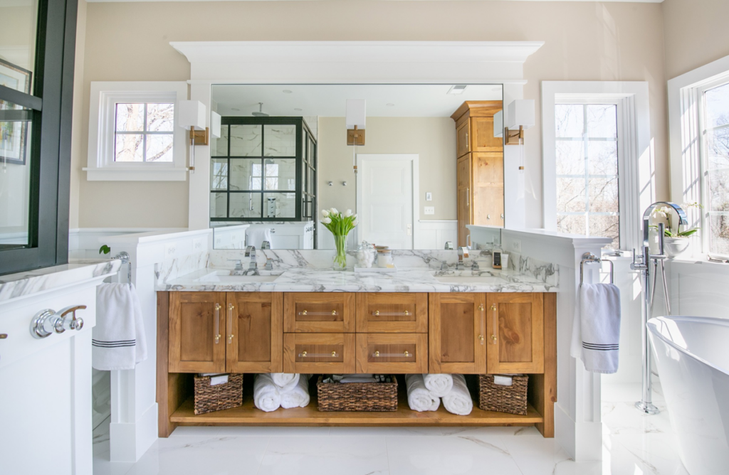 A newly installed custom wooden bathroom vanity with a marble countertop and double sinks by TCS Woodworking in Baltimore, MD