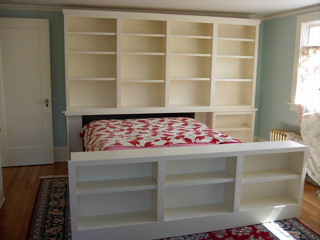 Custom bedroom built-in shelving and cabinet unit around a bed by Hessel Carpentry in Portland, OR.