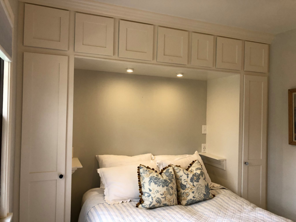 Custom built-in cabinets and shelving installed around a bed by Camelot Builders in Essex, CT.