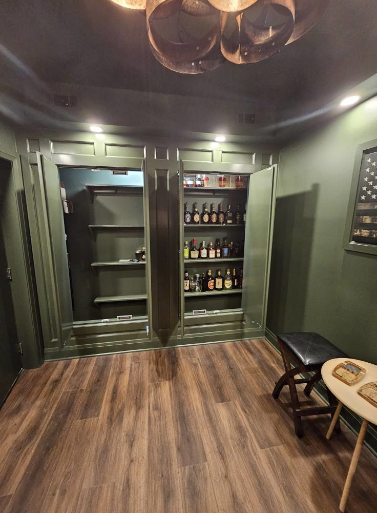 Custom built-in cabinets in a dark green room by Antalek Construction LLC in Erie, PA