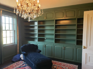 Custom built-in green bookshelves and cabinetry installed in a room by Kenneth C. Bergeron, Architect in Pollock, LA.
