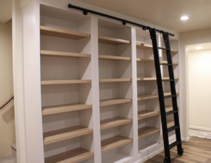 Custom built-in bookshelves with a rolling ladder installed by Krier's Construction, LLC in Oshkosh, WI.