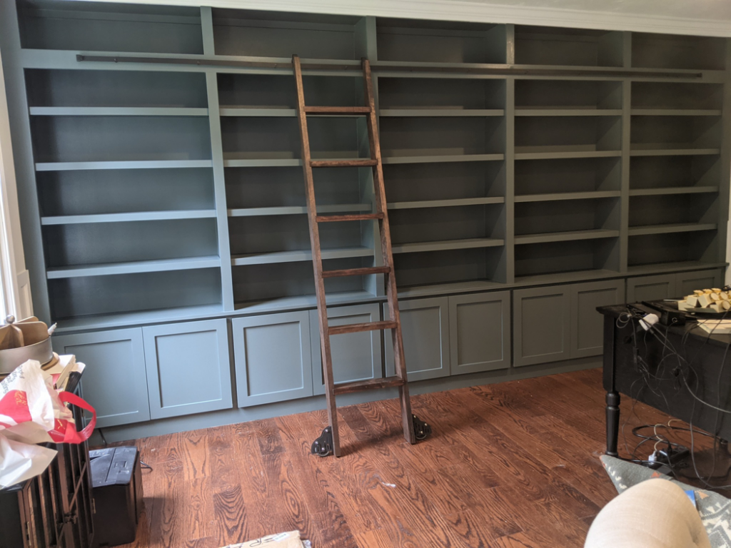 Custom built-in bookshelves with a rolling ladder in a home by Caldwell Construction in Richardson, TX