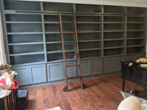 Custom built-in bookshelves with a rolling ladder in a home by Caldwell Construction in Richardson, TX