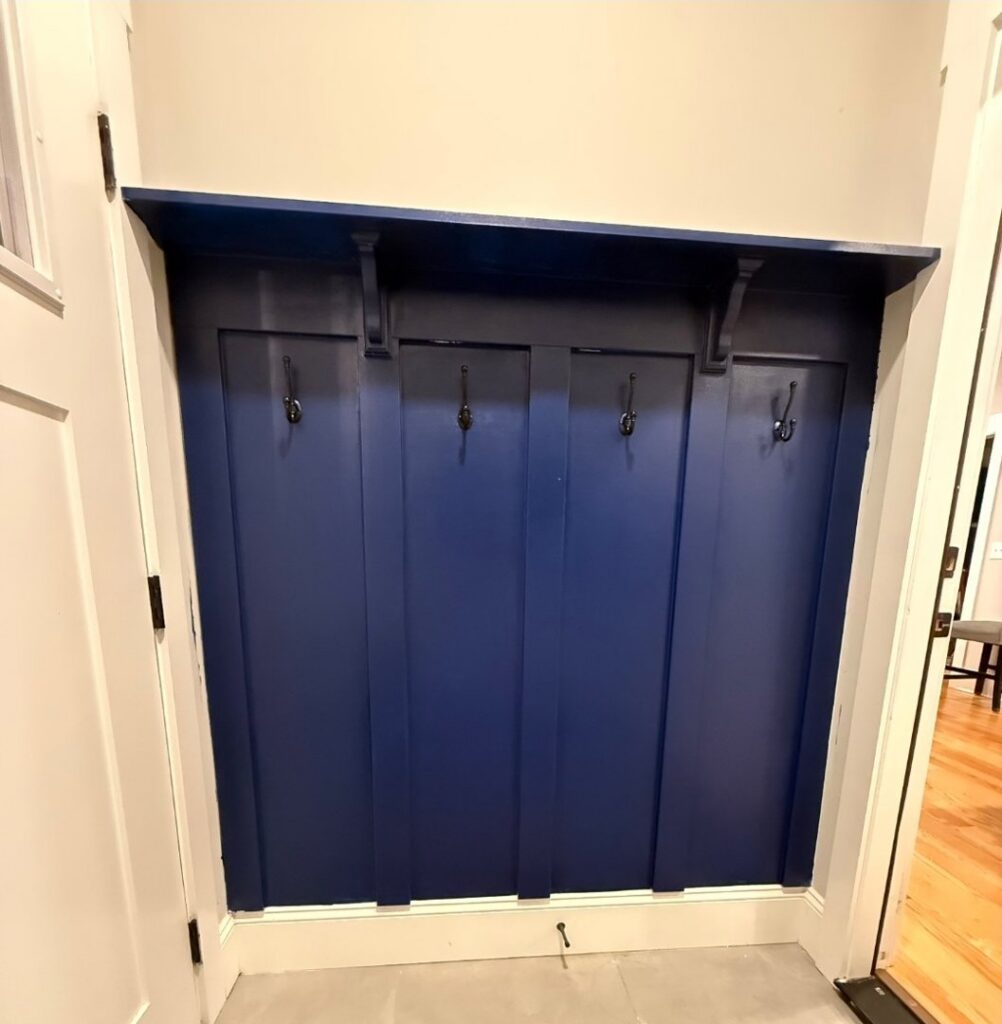 A newly installed custom built-in coat rack with hooks, painted blue, by Home FREA in Raleigh, NC.