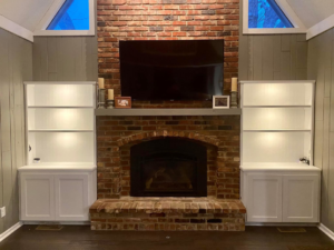 Custom built-in bookshelves installed on either side of a fireplace by Norbe's Home Solutions LLC in Lenexa, KS.