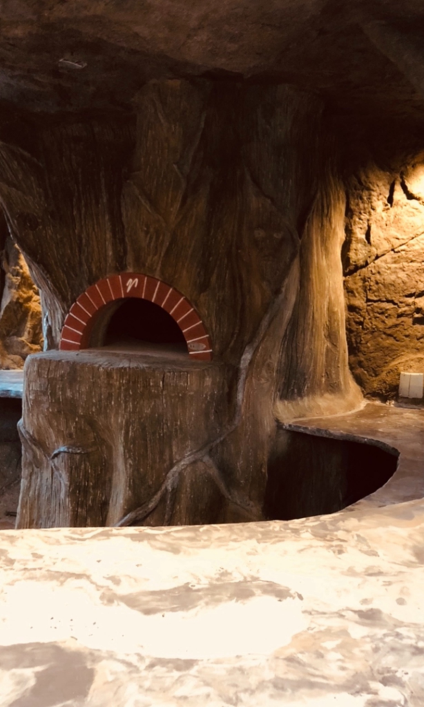 A custom-built outdoor pizza oven integrated into a stone structure by Burton Restoration LLC in Bend, OR.