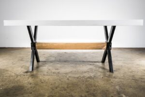 A custom-built outdoor table with a white top and unique metal and wood base by Constructive Design Group in Raleigh, NC