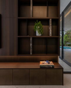 Custom-built dark wood shelving and cabinets by J Romano Group in Miami Beach, FL