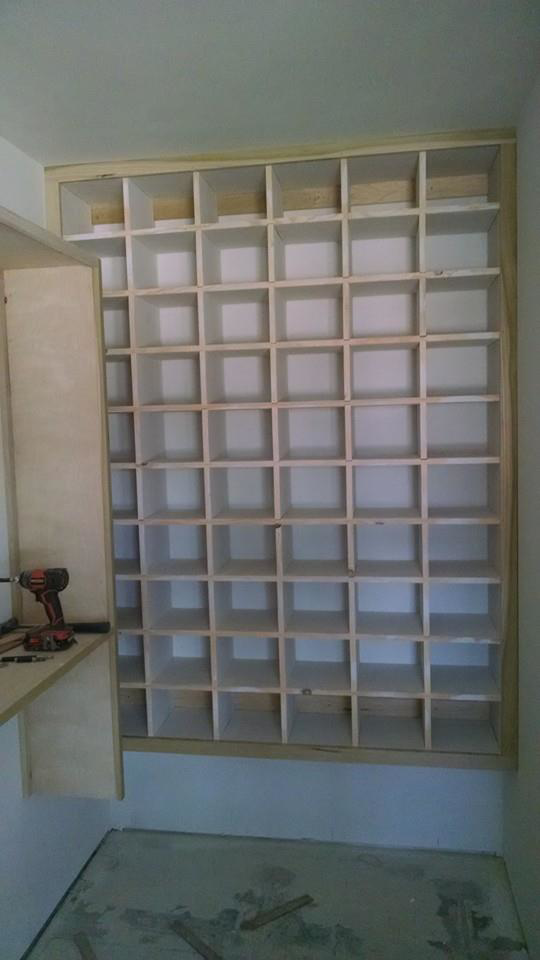 A custom-built shelving unit with multiple compartments installed by Cutler Builders in Caledonia, MI.