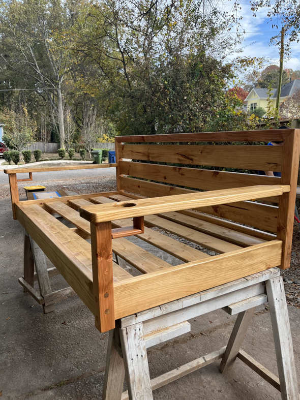 A custom-built wooden outdoor bench or swing frame, showcasing carpentry work by Under The Wire Renovations in Atlanta, GA.