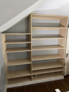 Custom-built wooden shelves expertly installed into an angled wall by Friendly Neighborhood Handyman in Uxbridge, MA.