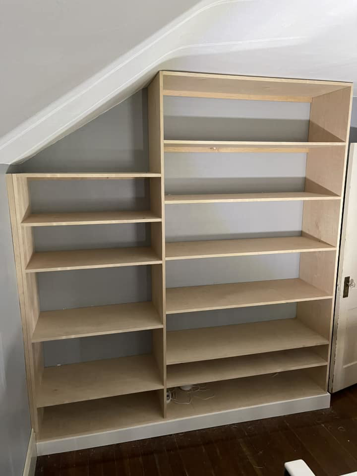 Custom-built wooden shelves expertly installed into an angled wall by Friendly Neighborhood Handyman in Uxbridge, MA.