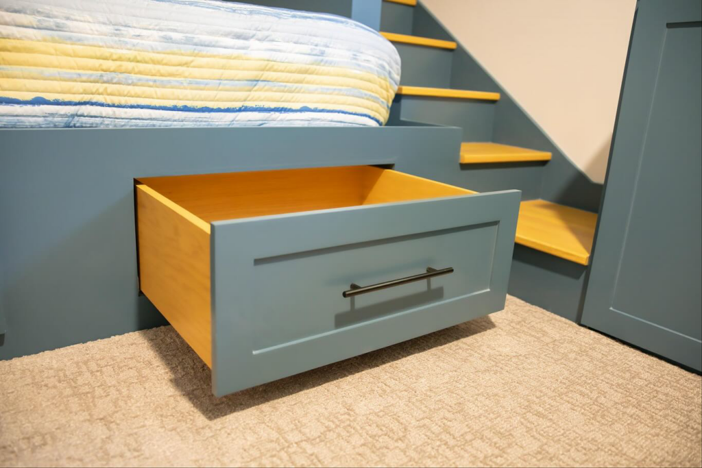 A close-up of an open custom built-in drawer from a bunk bed unit by An Extra Hand in Indianapolis, IN.