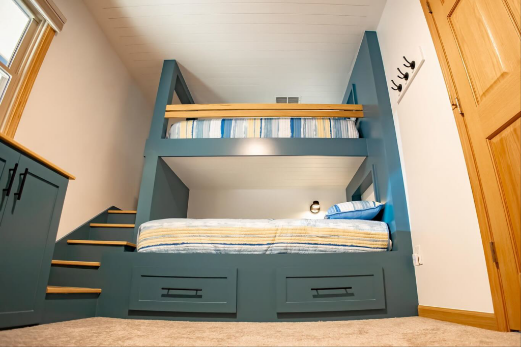 A side view of a custom built bunk bed unit with integrated stairs and built-in drawers by An Extra Hand in Indianapolis, IN.