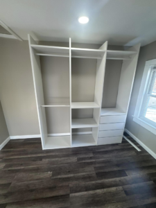A newly installed white custom closet and shelving system by Juan M Construction LLC in Waterbury, CT.