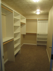 A spacious walk-in closet with custom shelving and hanging rods installed by Qual-i-Tee bilt homes - Steve Johnson in Salem, OR.