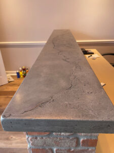 A custom concrete countertop with a unique textured finish installed on a brick base, crafted by M7 Remodel & Restoration Inc. in Houston, TX