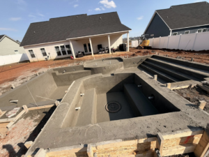 Custom concrete pool shell construction showing multiple sections and plumbing by Ga Impact Shotcrete in Atlanta, GA.