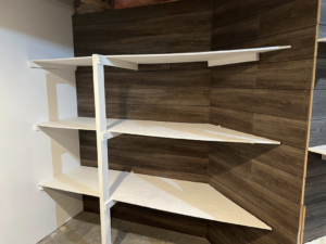 Custom white corner shelving installed against a wood-paneled wall by Halls Home Solutions in Pierre, SD