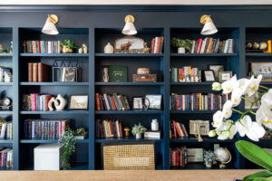 Custom dark blue built-in bookshelves with decorative lighting installed by HomePro Improvements, Roswell, GA.