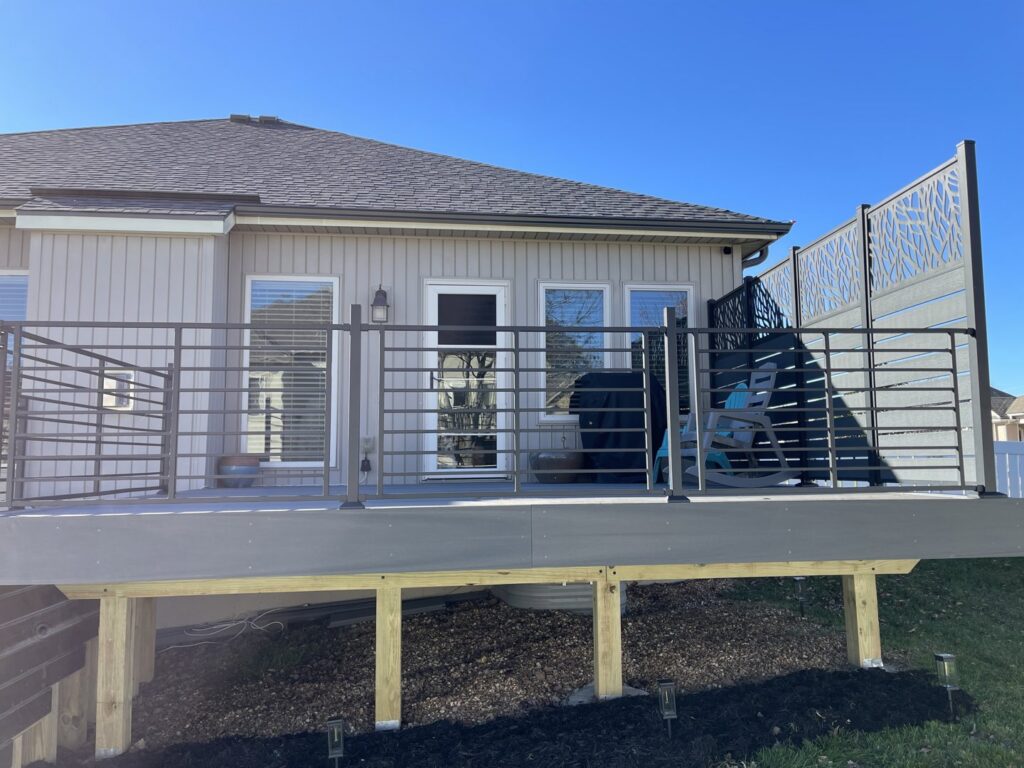 A custom deck design featuring modern railings and a decorative screen by Chad Fry the Deck Guy LLC in Blue Springs, MO.