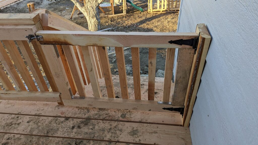 A custom wooden gate installed as part of a deck railing by Devil Dog Services LLC in Billings, MT.