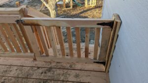 A custom wooden gate installed as part of a deck railing by Devil Dog Services LLC in Billings, MT.