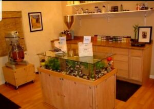 A room with a custom glass-top display case and shelving installed by Halpin Hands in Williams, OR.
