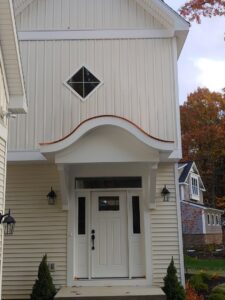Custom entryway with a unique copper awning and vertical siding completed by JB Home Improvement Services in Sanford, FL.
