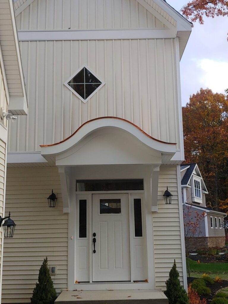 Custom entryway with a unique copper awning and vertical siding completed by JB Home Improvement Services in Sanford, FL.