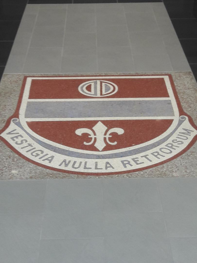 A custom decorative floor crest embedded in new tile flooring by Guaranteed Installations in Tampa, FL.
