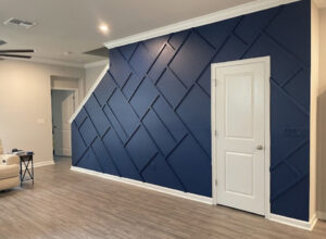 A stylish custom geometric accent wall with dark blue paneling and a white door, designed by Midwest Home Remodeling & Design LLC in Chicago, IL.