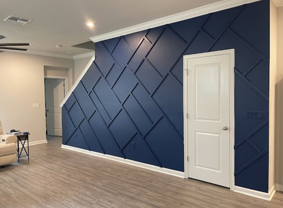 A stylish custom geometric accent wall with dark blue paneling and a white door, designed by Midwest Home Remodeling & Design LLC in Chicago, IL.