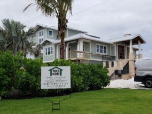 A custom home construction site with a 'Rock Homes' sign in the foreground, managed by Rock's Custom Homes in St. Petersburg, FL.
