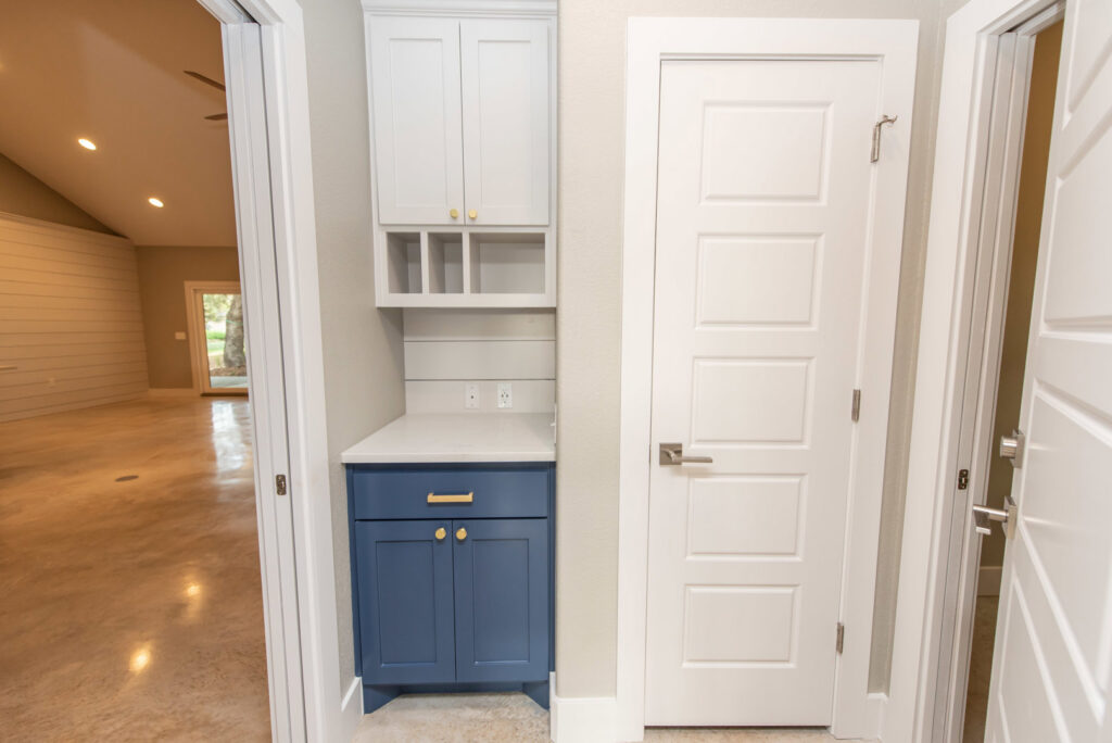 A custom home mudroom or entryway with built-in cabinetry and counter space by Aubrey Homes in Austin, TX