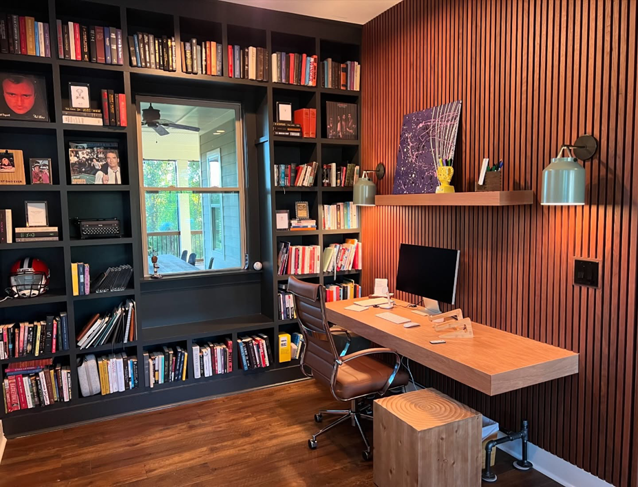 A custom-built home office with extensive bookshelves and a floating desk by Special Reserve Contracting in Charlotte, NC.