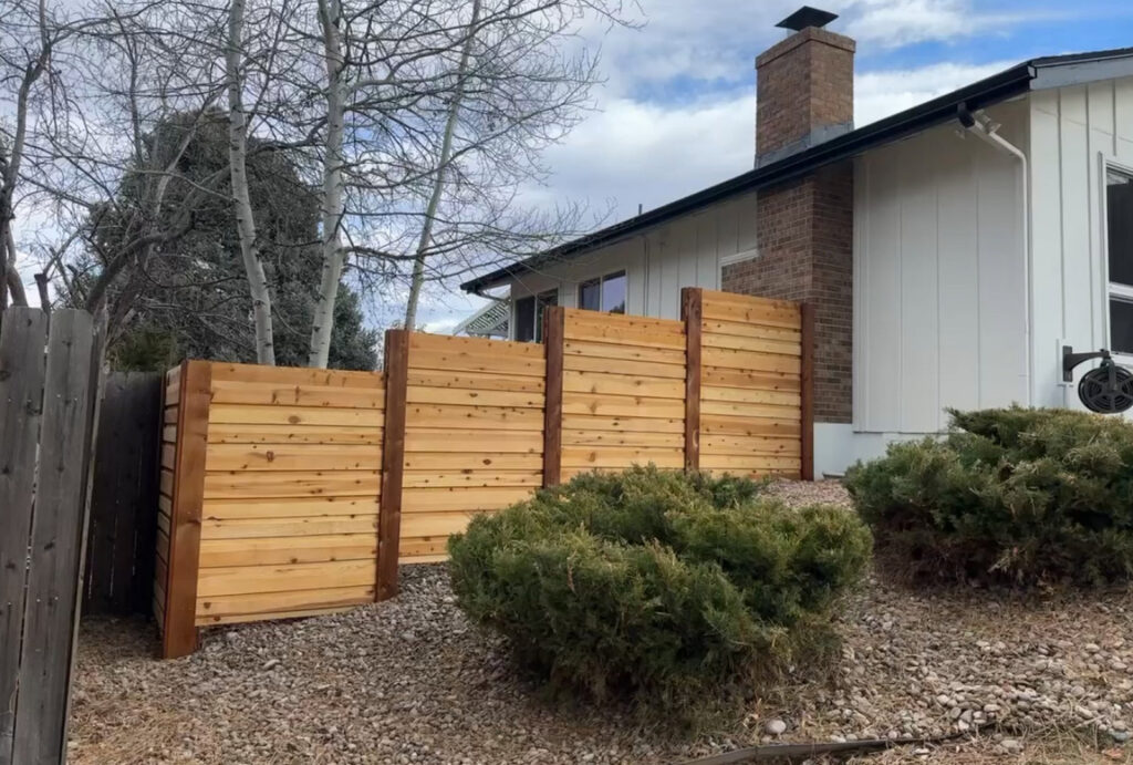 A custom horizontal wood fence section installed by GreenView Solutions in Denver, CO, next to a house.